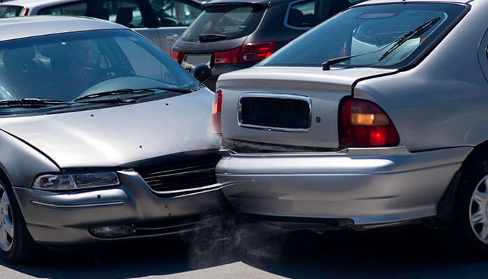 A rear-end collision between two silver cars, illustrating the concept of liability in personal injuries