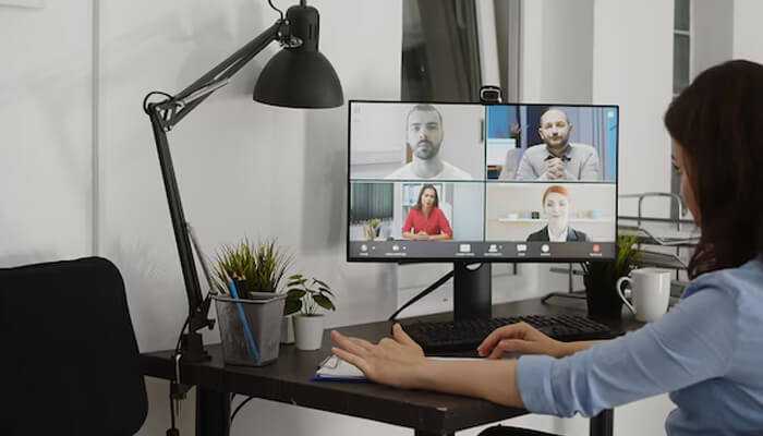 Remote workforce setup, where a woman joins a virtual meeting from her home office. It highlights remote collaboration using digital communication tools.