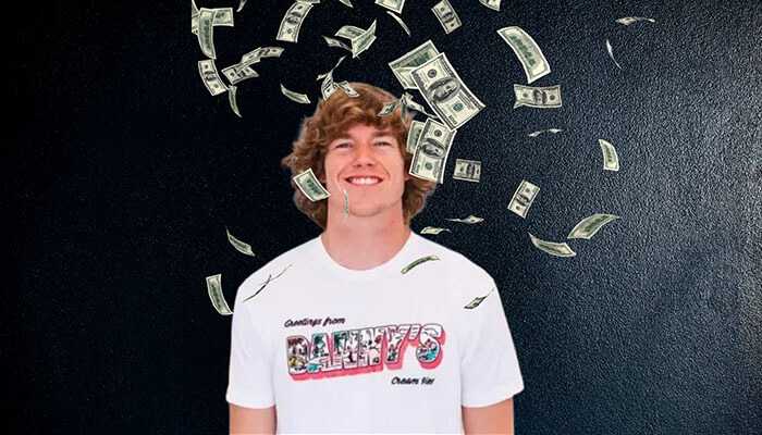 Danny duncan smiling while wearing a branded t-shirt, with dollar bills falling around him against a dark background, symbolizing wealth and success