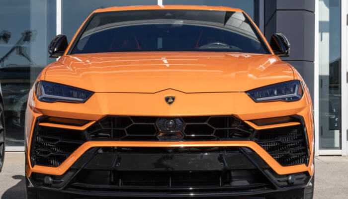 Luxury rental market and pricing | tycoonstory media Front view of an orange lamborghini urus parked outside a luxury showroom, representing lamborghini urus rental in dubai for premium travel experiences.