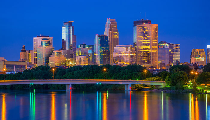 Vibrant night skyline with reflections on the water representing a modern property management company in a growing city.