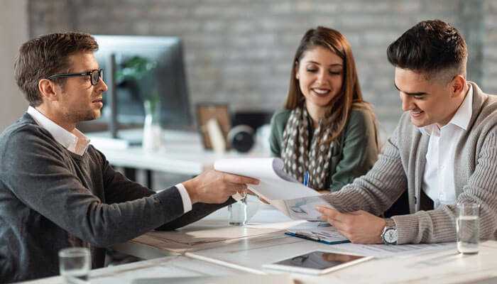 Business loan consultation with startup founders reviewing documents with a financial advisor – best small business loan options discussion.