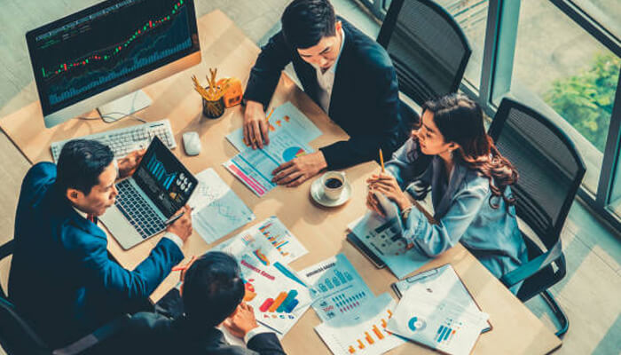 Team analyzing financial charts and discussing crypto solutions for fintech projects in a meeting room.