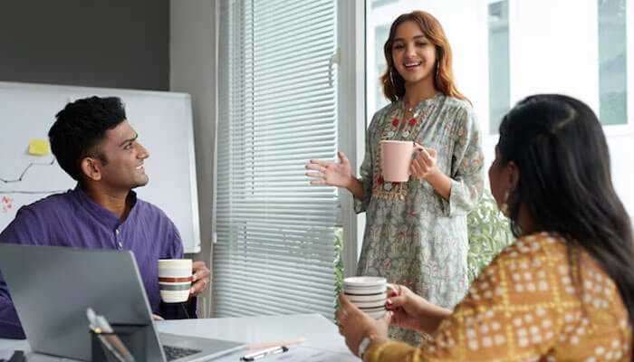 Patience and persistence - tycoonstory | tycoonstory media Team discussion in office on leadership strategies for making change stick, with employees collaborating and sharing ideas during a meeting.