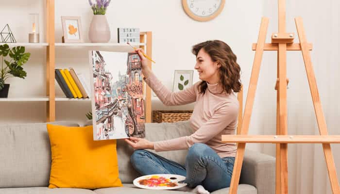 Creative woman painting on canvas at home as part of her high-profit home business venture