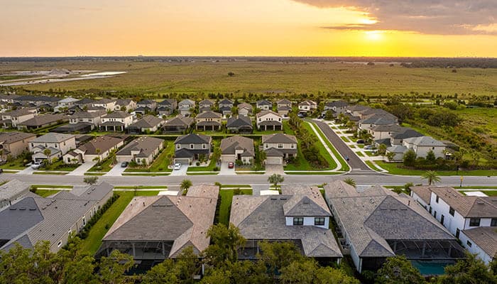 Housing market in australia shown through aerial view of suburban residential neighborhood at sunset.