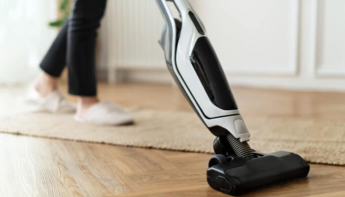 Close-up view of a sleek modern vacuum gliding across a wooden floor, representing intelligent design and powerful suction technology.
